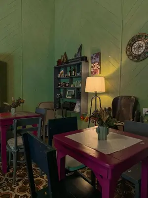 a dining room with tables and chairs and a lamp at Hostal Brunette Santein in Santa Ana