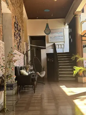 a living room with a chair and a staircase at Hostal Brunette Santein in Santa Ana