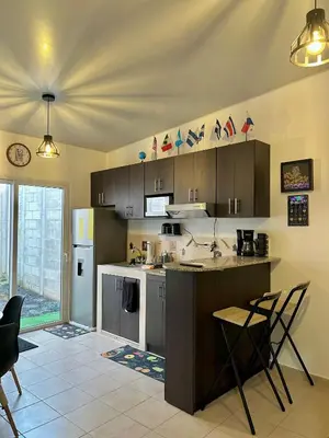a kitchen with a counter and chairs in a room at La Casita del Viajero in Santa Ana