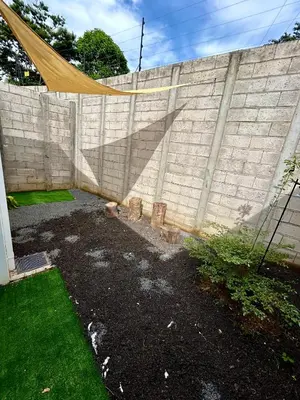 a backyard with a retaining wall and a fence at La Casita del Viajero in Santa Ana