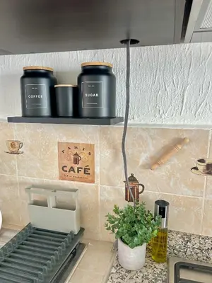 a kitchen counter with two shelves with pots and pans at La Casita del Viajero in Santa Ana