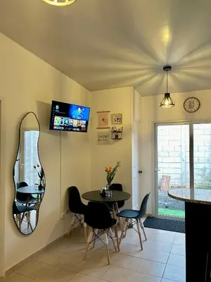 a dining room with a table and chairs and a tv at La Casita del Viajero in Santa Ana