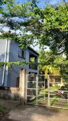 a house behind a fence with a gate at Nawa Kalli Surf House in El Sunzal