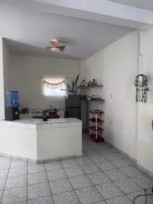 a kitchen with a white counter and a refrigerator at Nawa Kalli Surf House in El Sunzal