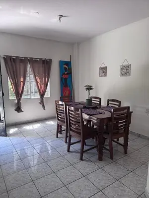 a dining room with a wooden table and chairs at Nawa Kalli Surf House in El Sunzal