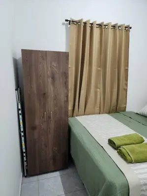a bedroom with a bed and a wooden cabinet at Casa Villa El Escape en Residencial Villa Panamericana in San Miguel