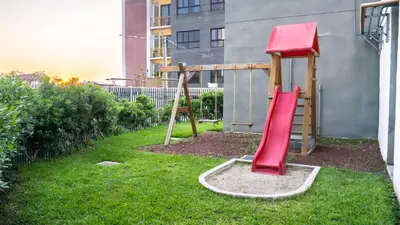 a playground with a red slide in a yard at Brisa Serena Apartamento con parqueo y gran terraza en La Escalón in San Salvador