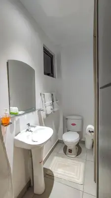 a white bathroom with a sink and a toilet at Brisa Serena Apartamento con parqueo y gran terraza en La Escalón in San Salvador