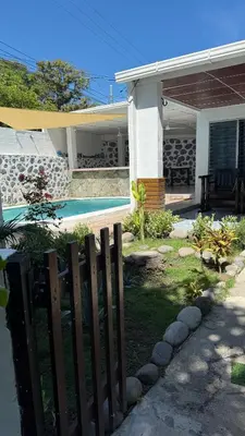 a fence in front of a house with a pool at El Rinconcito in La Libertad