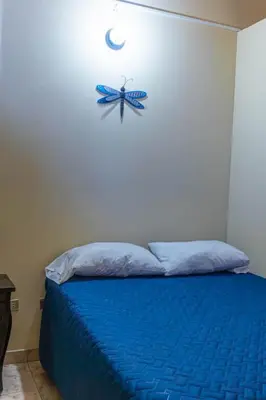 a bedroom with a blue bed with a fish on the wall at Hostal Casa Luna in Santa Ana