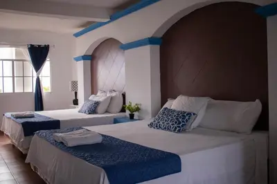 two beds in a room with blue and white at Casa Coral in Los Cóbanos