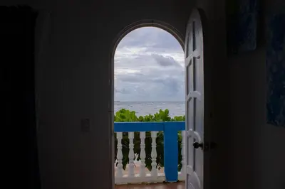 an open door to a balcony with a view of the ocean at Casa Coral in Los Cóbanos