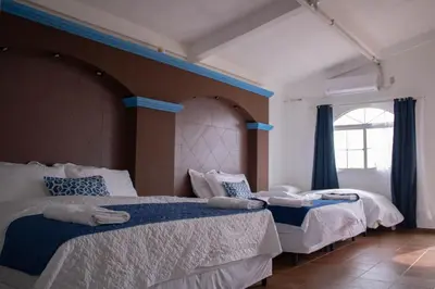 a bedroom with two beds and a large window at Casa Coral in Los Cóbanos