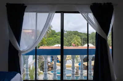 a view of a pool from a bedroom window at Casa Coral in Los Cóbanos