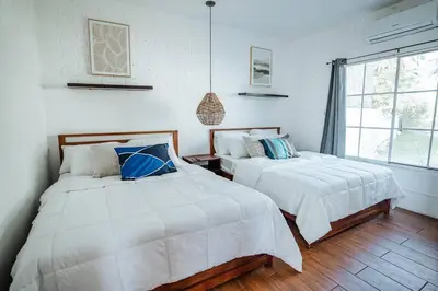 a bedroom with two beds and a window at Cabo in Las Hojas