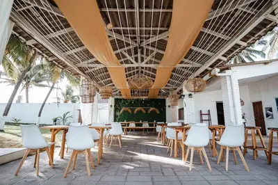 a dining room with tables and white chairs at Cabo in Las Hojas