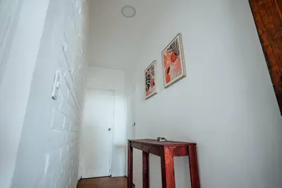 a hallway with a wooden table and a white wall at Cabo in Las Hojas