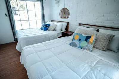 two white beds in a room with windows at Cabo in Las Hojas
