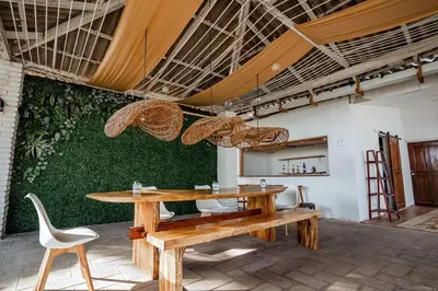a dining room with a table and a green wall at Cabo in Las Hojas