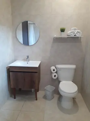 a bathroom with a toilet and a sink and a mirror at Charlys Place in San Salvador