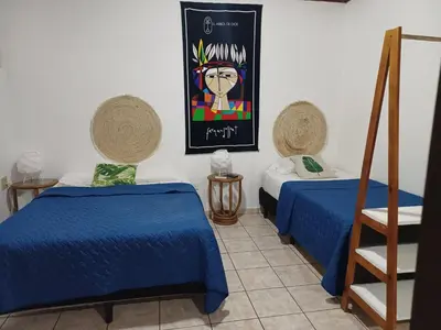 a room with two beds and a poster on the wall at Charlys Place in San Salvador