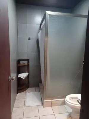 a bathroom with a shower and a toilet at Charlys Place in San Salvador