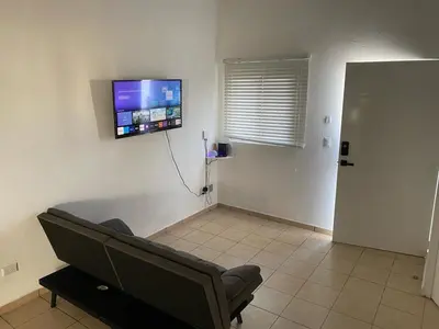 a living room with a couch and a tv on the wall at Ecoterra villas del sol in Comecayo