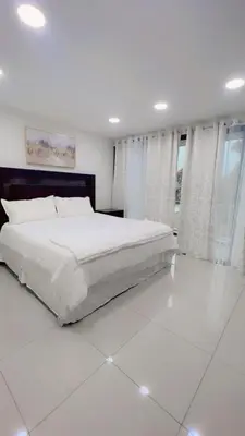 a white bedroom with a large white bed in it at Stylish house close to tourist attractions in La Libertad