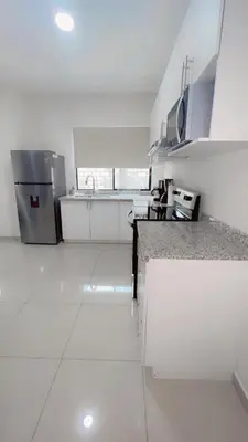 a kitchen with white appliances and a white floor at Stylish house close to tourist attractions in La Libertad