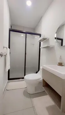 a white bathroom with a shower and a toilet at Stylish house close to tourist attractions in La Libertad