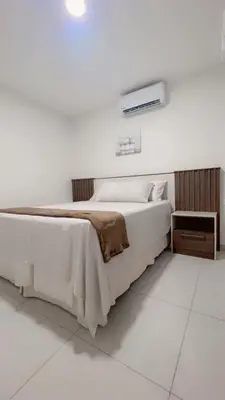 a white bedroom with a bed and a air conditioner at Stylish house close to tourist attractions in La Libertad