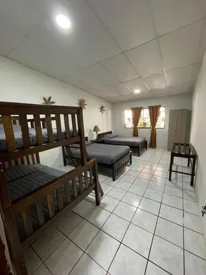 a room with three bunk beds and a tiled floor at Apaneca House in Apaneca