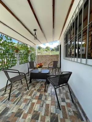 a patio with chairs and a table and a table at Apaneca House in Apaneca