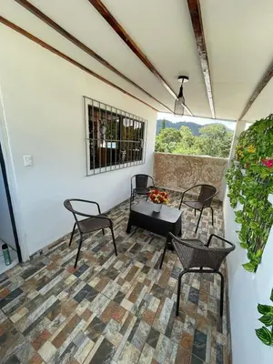 a patio with chairs and a table and a window at Apaneca House in Apaneca