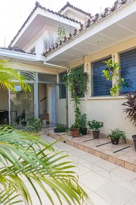 a house with potted plants on the porch at Hostal CASA LUNA in Santa Ana