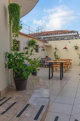 a patio with tables and potted plants on a building at Hostal CASA LUNA in Santa Ana