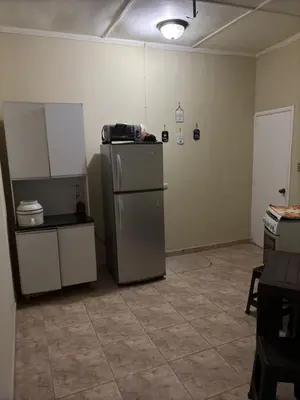 an empty kitchen with a refrigerator in a room at Hostal CASA LUNA in Santa Ana