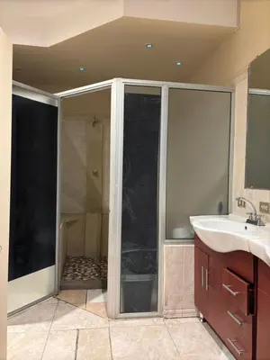 a bathroom with a glass shower and a sink at Hostal CASA LUNA in Santa Ana