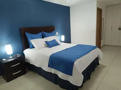 a blue bedroom with a large bed with blue walls at Apartamento Martz en colonia San Francisco in San Salvador