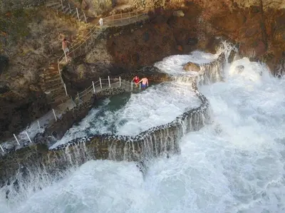 two people standing on a waterfall in the water at Casa Las Doroteo in El Sunzal