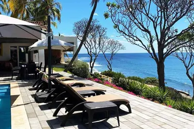 a row of tables and chairs next to the ocean at Casa Las Doroteo in El Sunzal