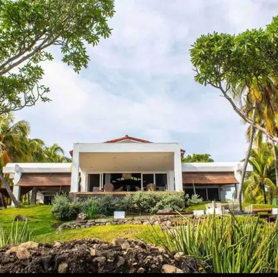 a large white house with trees in front of it at Casa Las Doroteo in El Sunzal
