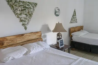 a bedroom with two beds and a table with a lamp at Las Cabañitas in San Salvador