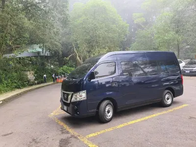 a blue van parked in a parking lot at Las Cabañitas in San Salvador