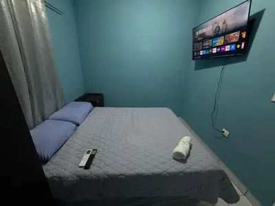 a bedroom with a bed with a tv on the wall at Casa en Nueva Metropolis con aire en toda la casa in San Miguel