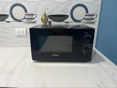 a black microwave sitting on a counter next to bowls at Casa en Nueva Metropolis con aire en toda la casa in San Miguel