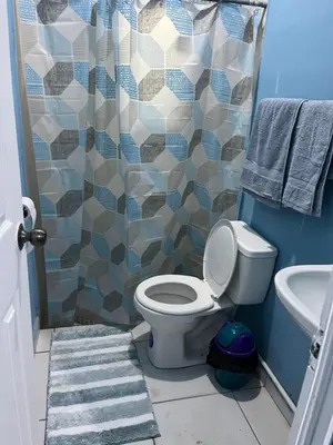 a bathroom with a toilet and a shower at Casa en Nueva Metropolis con aire en toda la casa in San Miguel