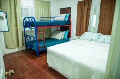 a bedroom with two bunk beds and a bed at Rancho El Ancla Surf City Wi-Fi AC Pool in La Libertad