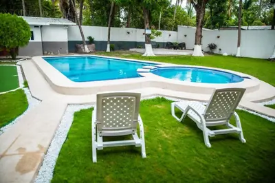 two chairs and a swimming pool in a yard at Rancho El Ancla Surf City Wi-Fi AC Pool in La Libertad