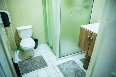 a bathroom with a shower and a toilet and a sink at Rancho El Ancla Surf City Wi-Fi AC Pool in La Libertad
